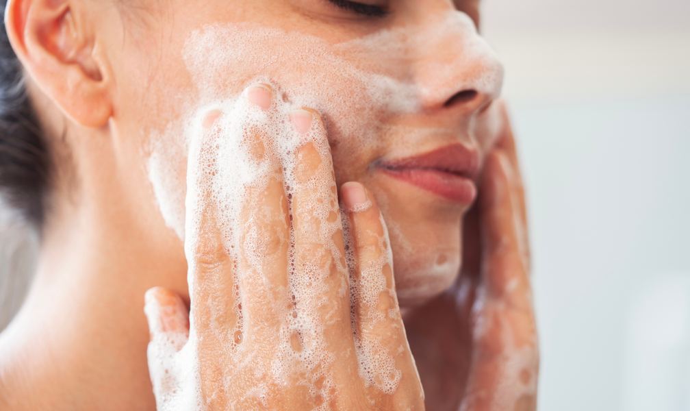 Close-up of a woman gently washing her face with a simple skincare routine